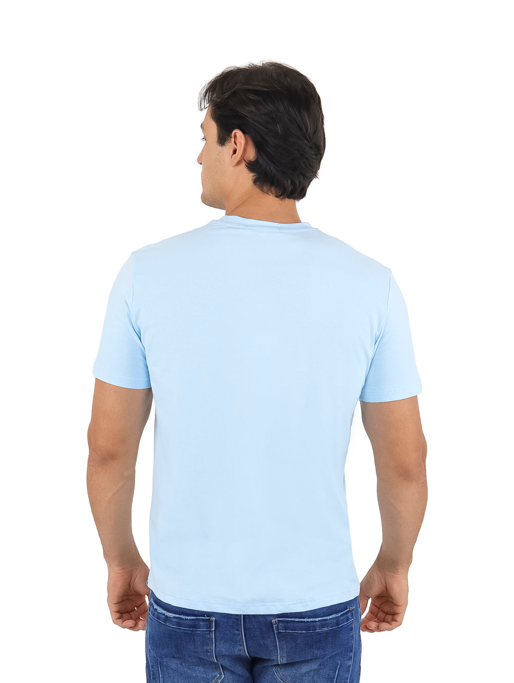 Hombre vistiendo playera azul claro de manga corta con estampado gráfico frontal y pantalones jeans azules.