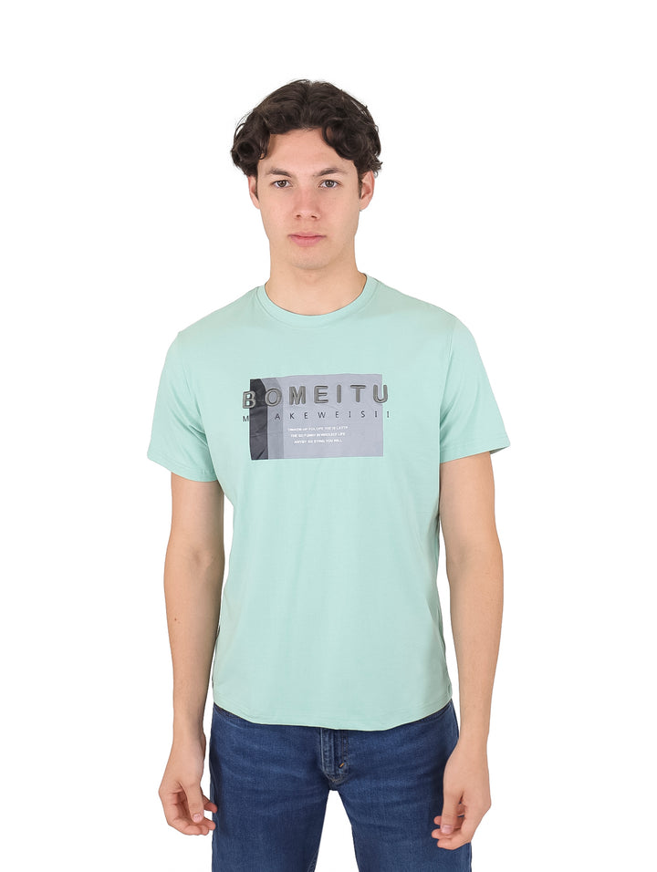 Hombre vistiendo playera de manga corta color verde menta con estampado gráfico en el pecho.