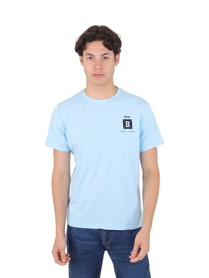 Hombre vistiendo una playera azul claro de manga corta con un pequeño logo en el pecho.