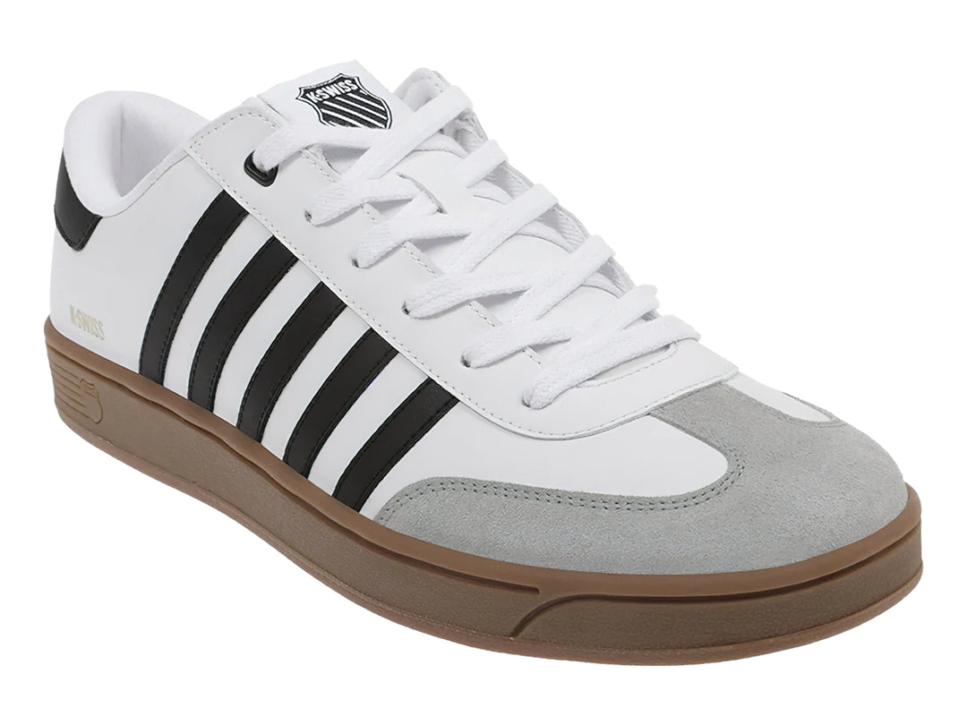 Tenis K-Swiss blancos con rayas negras laterales, punta gris y suela color café.