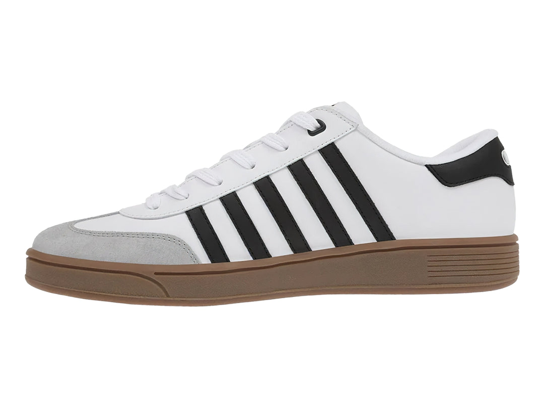 Tenis K-Swiss blancos con rayas negras laterales, punta gris y suela color café.
