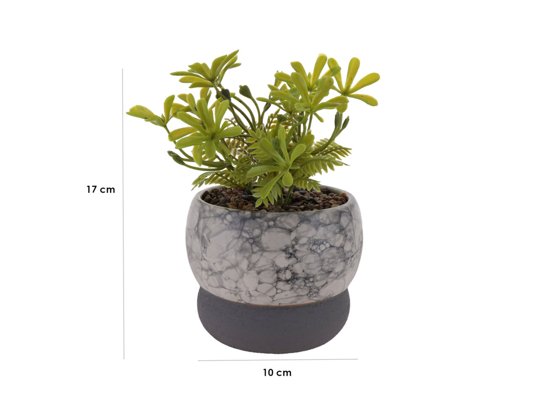 Planta artificial decorativa en maceta de cerámica con acabado de mármol blanco y base gris oscuro.