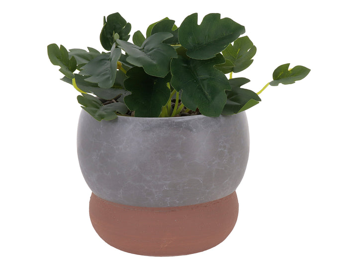 Planta artificial en maceta decorativa de dolomita con acabado en mármol gris y base marrón.