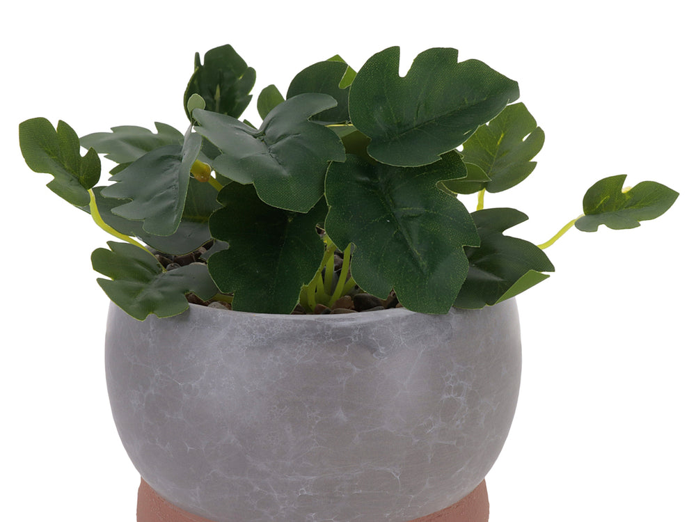 Planta artificial en maceta decorativa de dolomita con acabado en mármol gris y base marrón.