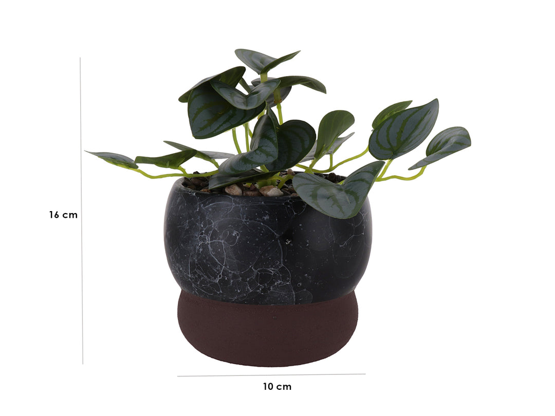 Planta artificial verde en maceta decorativa de mármol negro con base marrón.