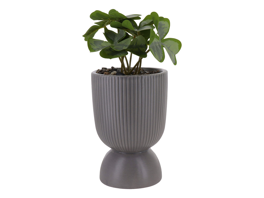 Planta artificial en maceta decorativa de dolomita color gris con textura acanalada y base circular.