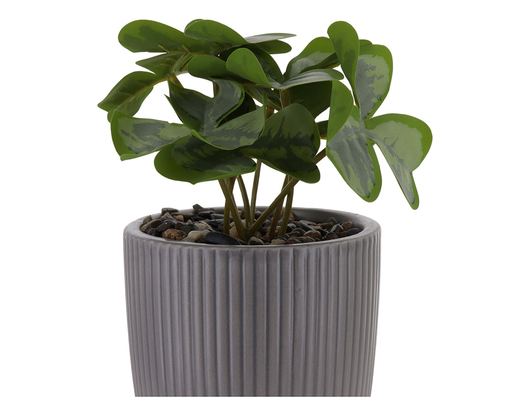 Planta artificial en maceta decorativa de dolomita color gris con textura acanalada y base circular.