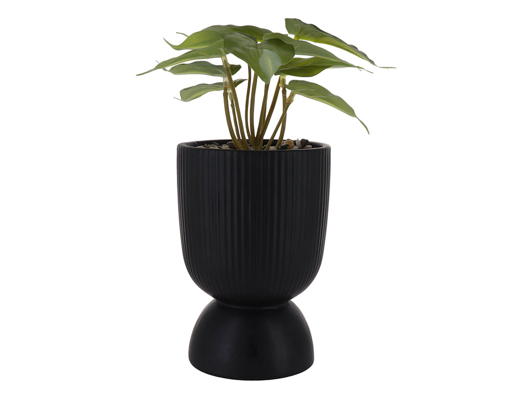 Planta artificial verde en maceta decorativa de dolomita color negro con textura acanalada y base redondeada.