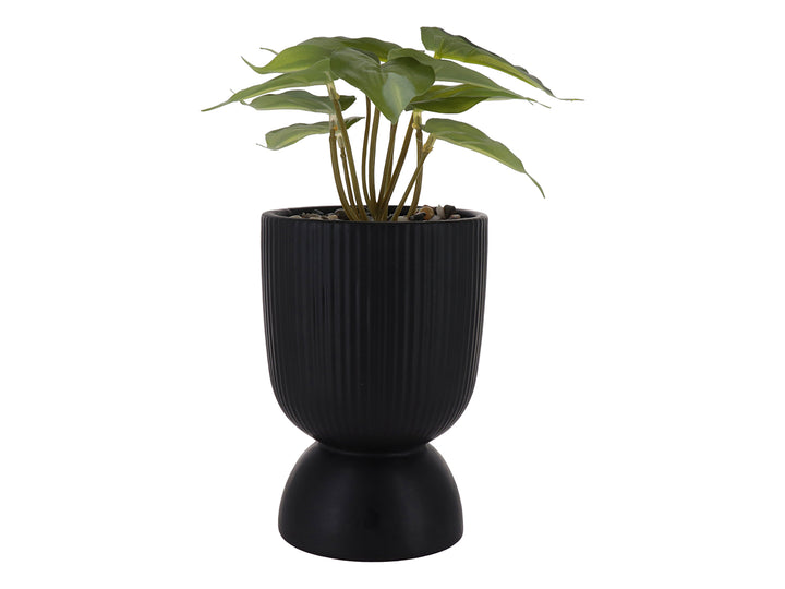 Planta artificial verde en maceta decorativa de dolomita color negro con textura acanalada y base redondeada.