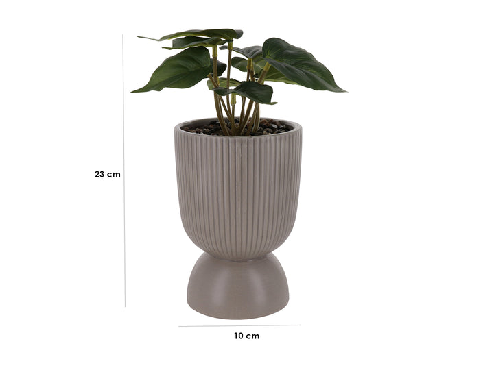 Planta artificial verde en maceta decorativa de dolomita color beige con diseño acanalado y base redondeada.