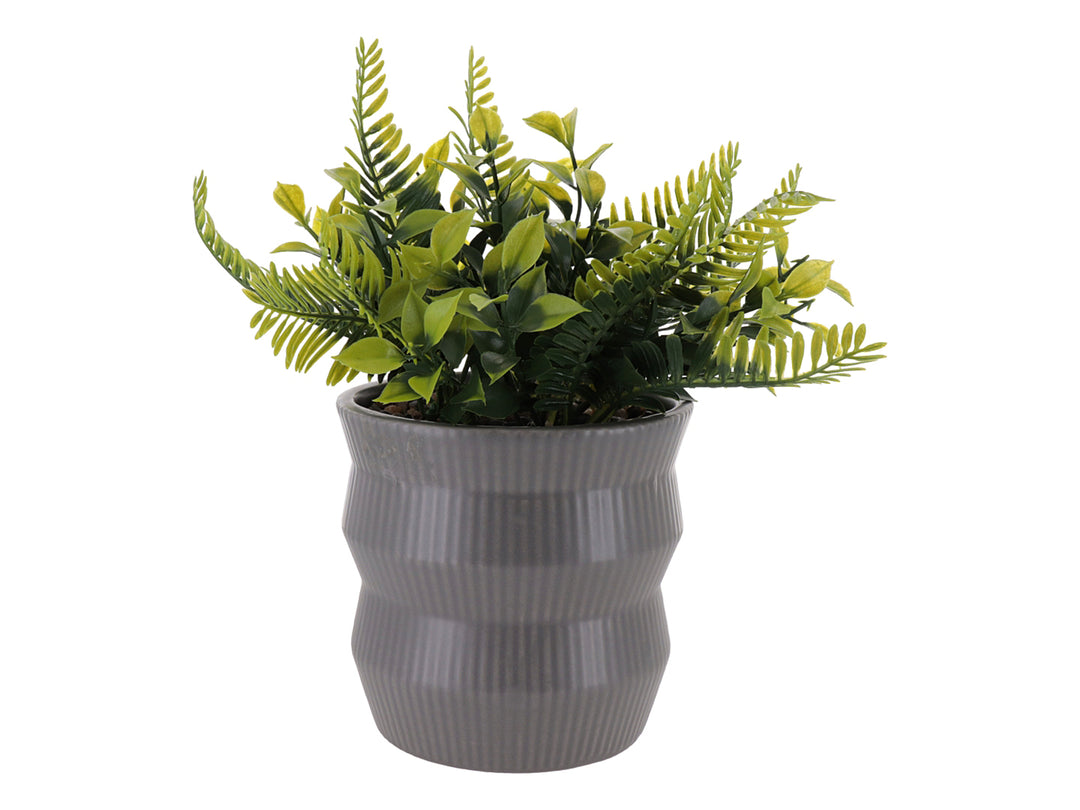 Planta artificial verde en maceta de dolomita gris con diseño acanalado.