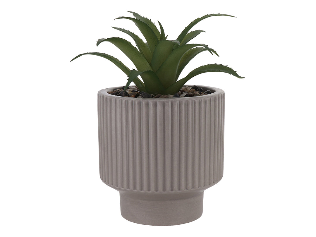 Planta artificial verde en maceta decorativa de dolomita color beige con textura acanalada.