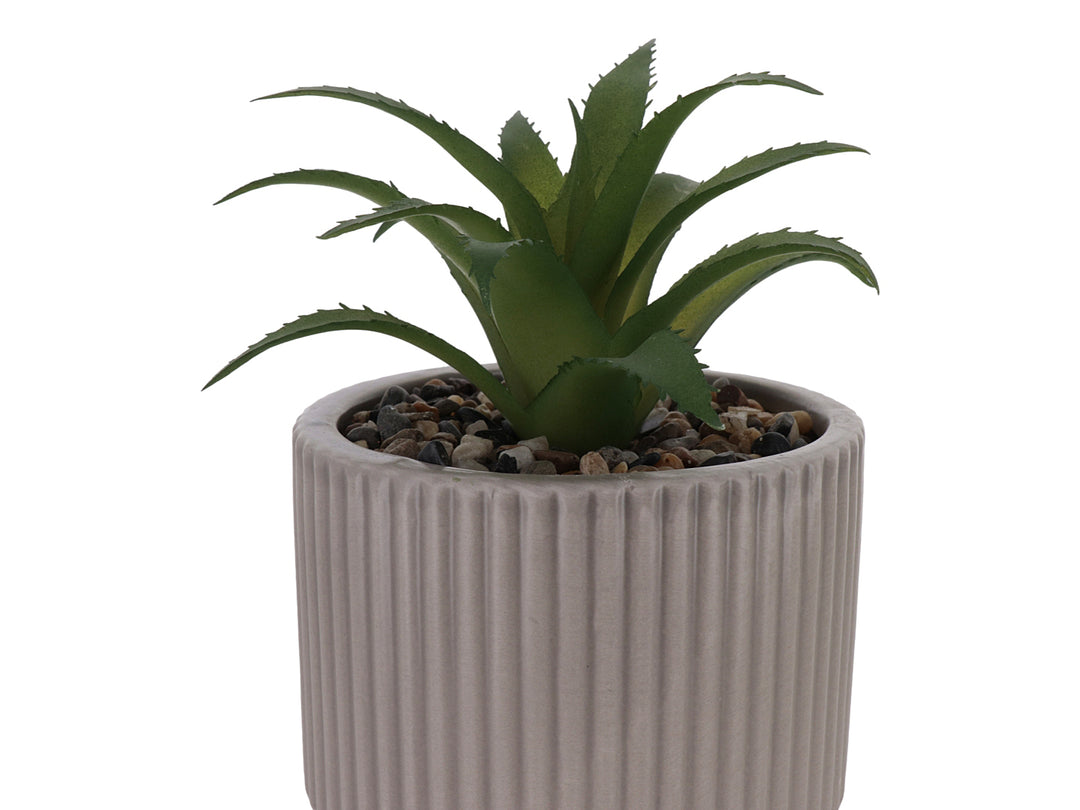 Planta artificial verde en maceta decorativa de dolomita color beige con textura acanalada.