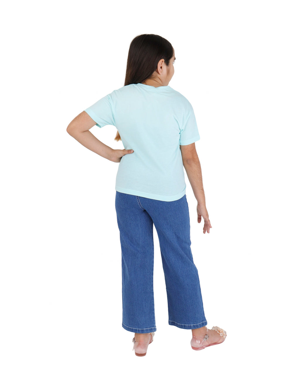 Niña vistiendo un conjunto de camiseta color menta con estampado y pantalón azul de mezclilla