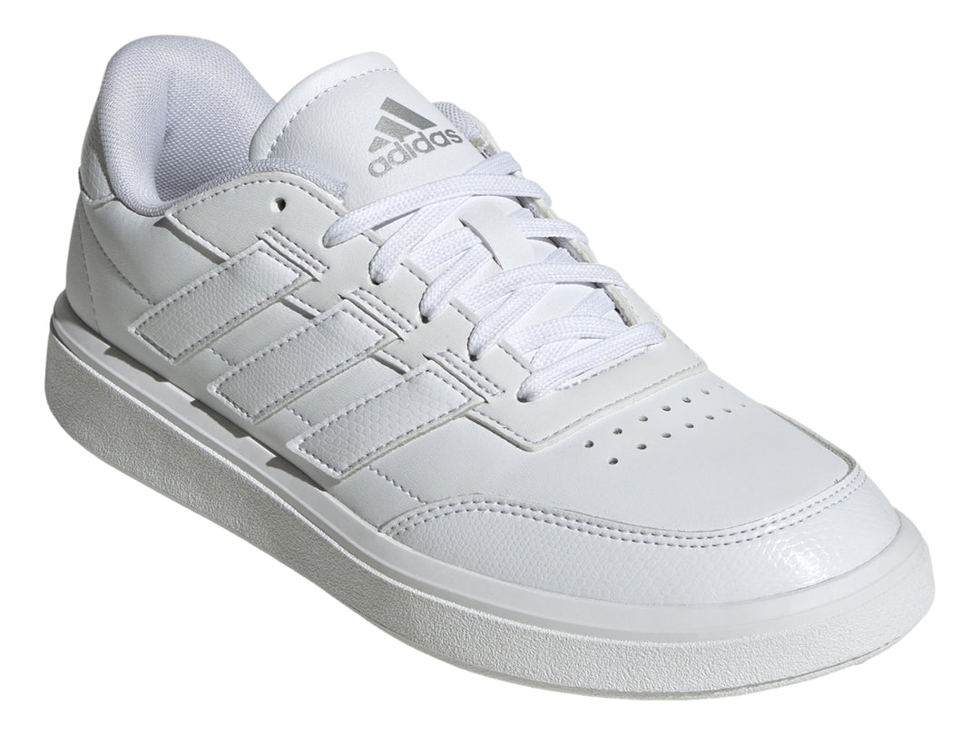 Tenis Adidas blancos con franjas laterales en color plata mate y suela blanca.