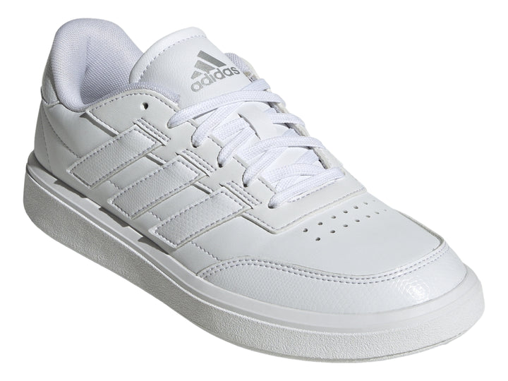 Tenis Adidas blancos con franjas laterales en color plata mate y suela blanca.