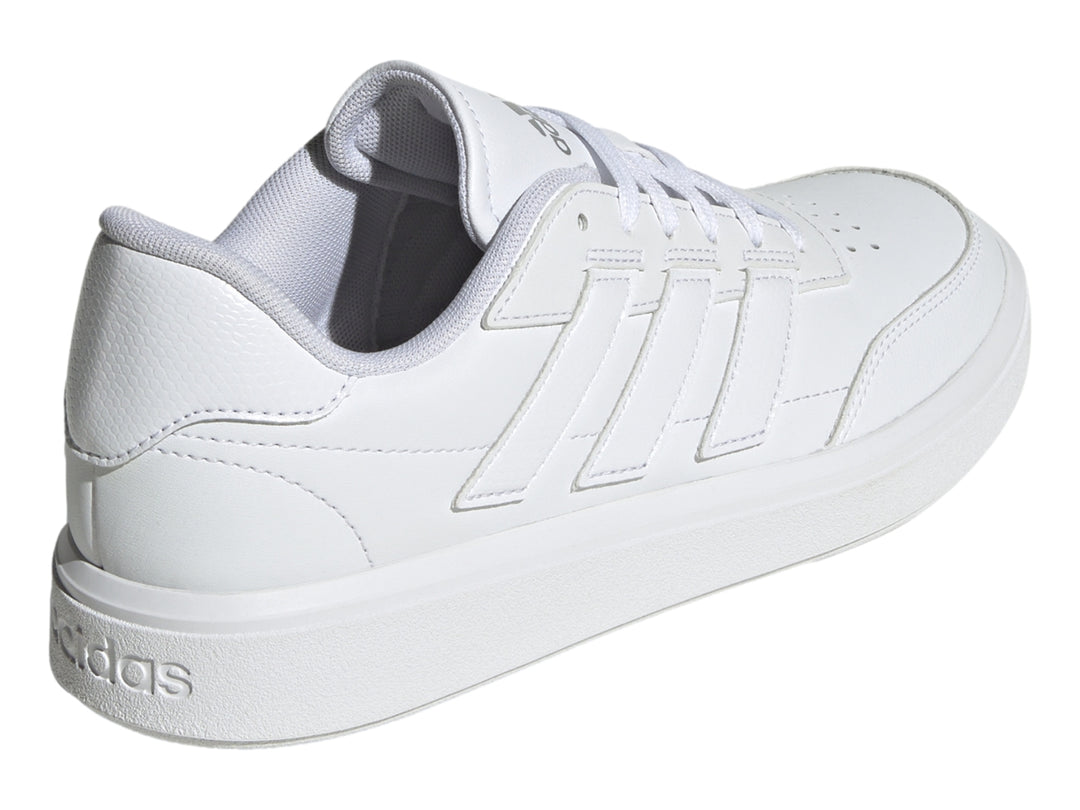 Tenis Adidas blancos con franjas laterales en color plata mate y suela blanca.