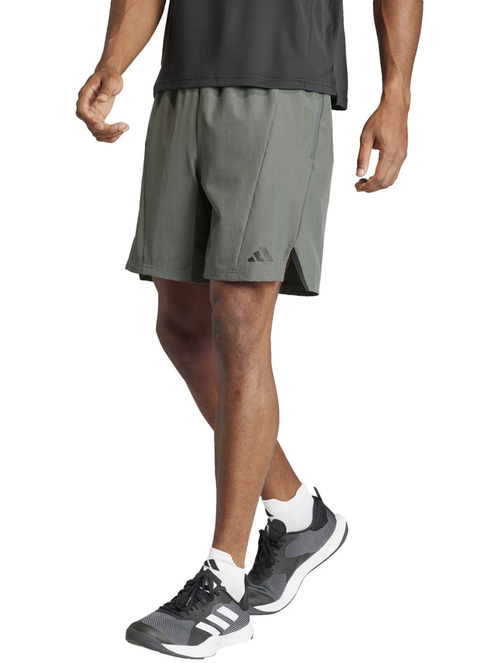 Hombre vistiendo pantalones cortos deportivos Adidas en color verde oliva Legend Ivy.