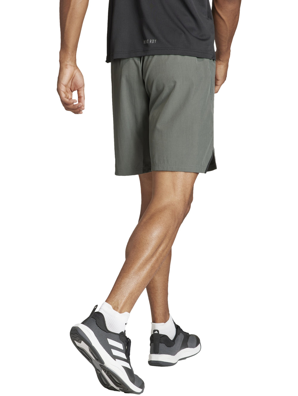 Hombre vistiendo pantalones cortos deportivos Adidas en color verde oliva Legend Ivy.