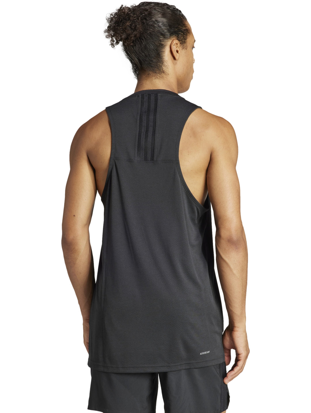 Hombre vistiendo una camiseta deportiva sin mangas de color negro con logotipo de Adidas en el pecho.