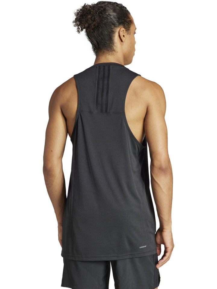 Hombre vistiendo una camiseta deportiva sin mangas de color negro con logotipo de Adidas en el pecho.