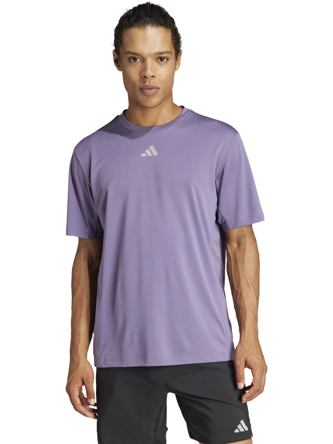 Hombre vistiendo una camiseta deportiva Adidas de color morado Shadow Violet.
