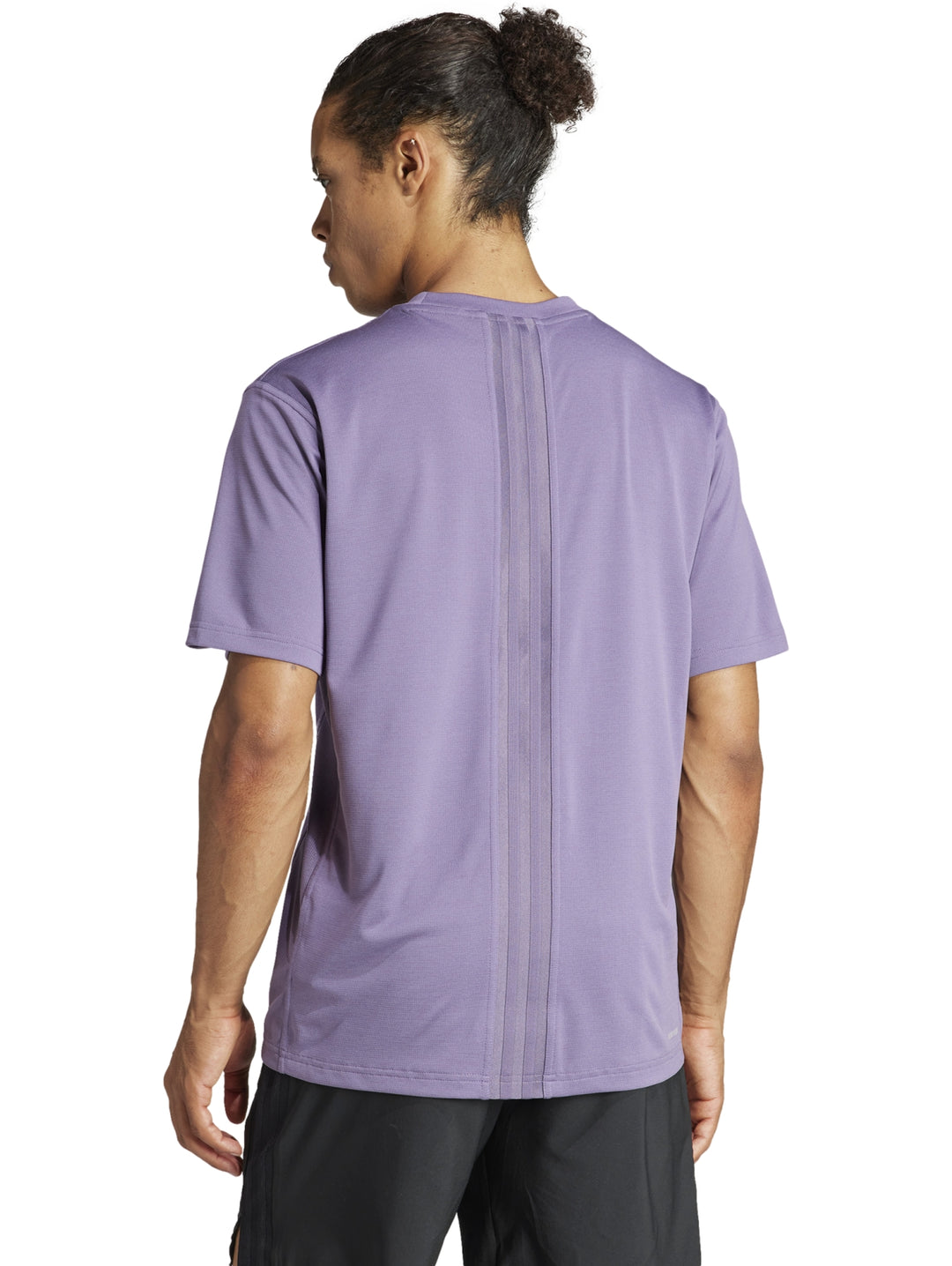 Hombre vistiendo una camiseta deportiva Adidas de color morado Shadow Violet.
