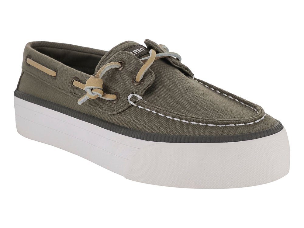 Zapato Sperry estilo náutico en color verde con suela blanca ancha y cordones beige.