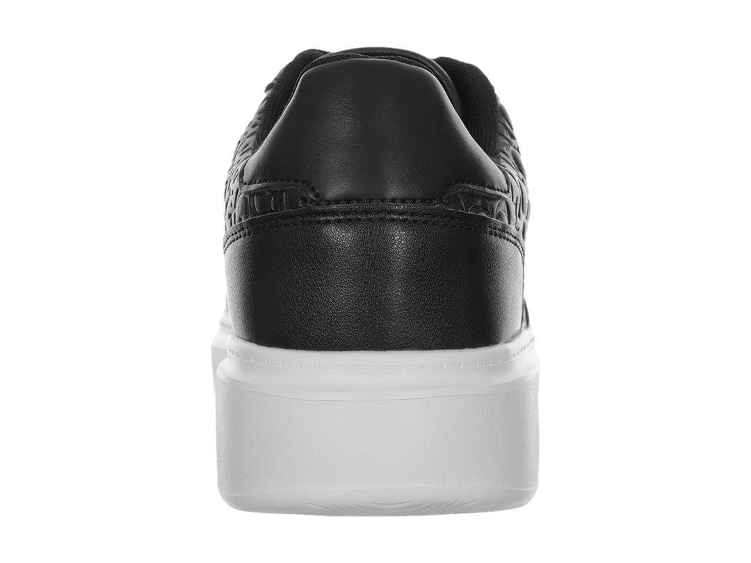 Tenis negros de la marca Guess con suela blanca y diseño grabado en relieve en la parte superior.