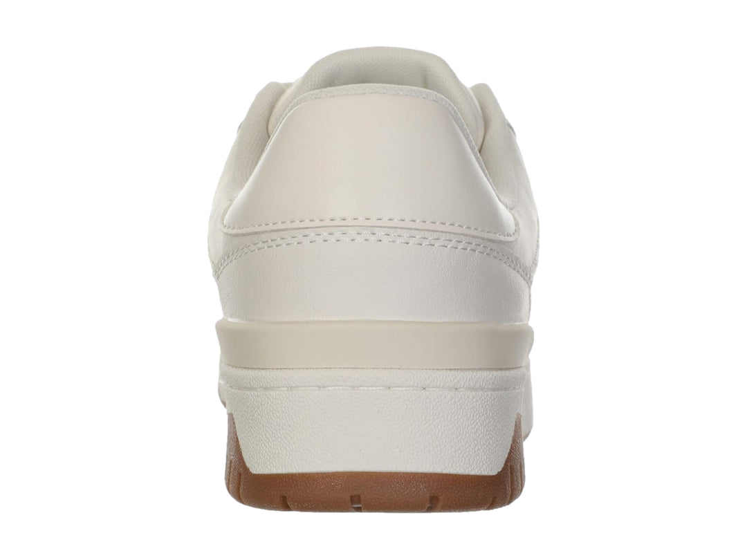 Tenis Guess color beige con suela blanca y café, diseño casual con logo grabado en el lateral.