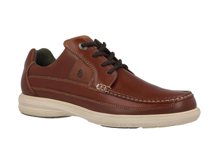 Zapato casual Hush Puppies de cuero color tan con cordones y suela blanca.