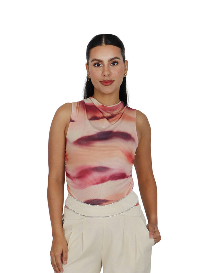 Mujer vistiendo un bodysuit Steve Madden sin mangas con estampado abstracto en tonos rosa y morado.