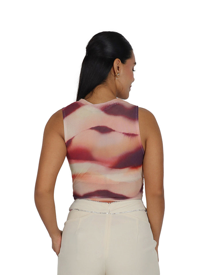 Mujer vistiendo un bodysuit Steve Madden sin mangas con estampado abstracto en tonos rosa y morado.