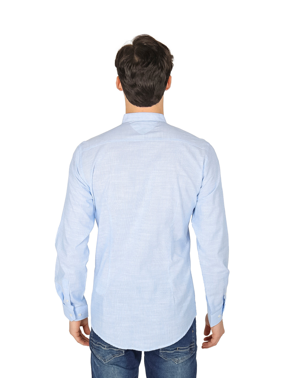 Hombre vistiendo camisa slim azul claro de manga larga con cuello mao y pantalones jeans azules.