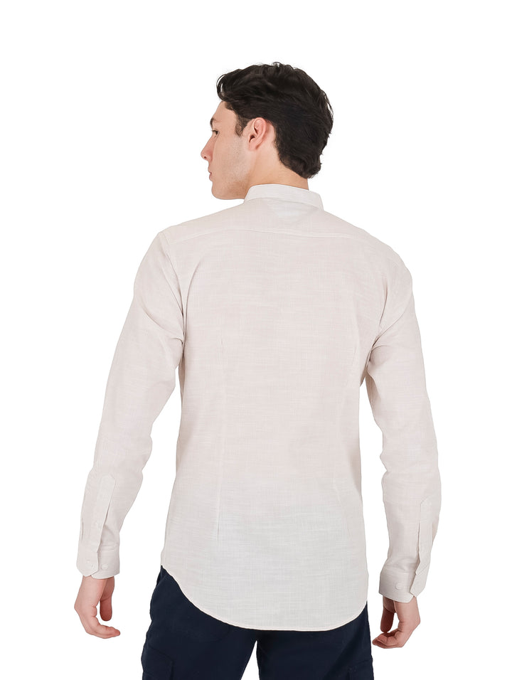 Hombre vistiendo una camisa slim fit de color arena con cuello mao y manga larga.