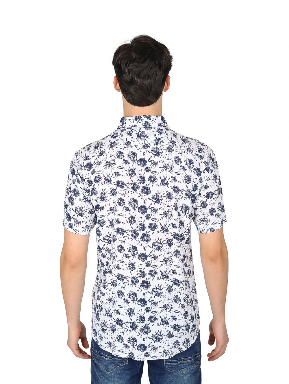 Hombre vistiendo camisa blanca de manga corta con estampado floral marino y pantalones vaqueros.