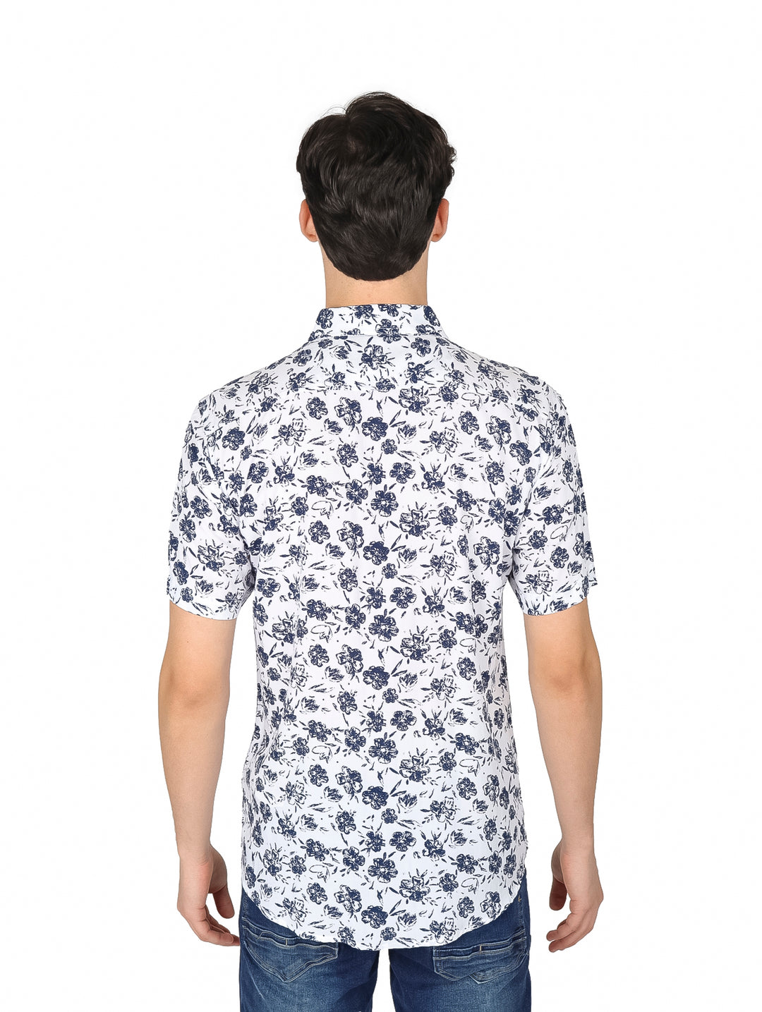 Hombre vistiendo camisa blanca de manga corta con estampado floral marino y pantalones vaqueros.