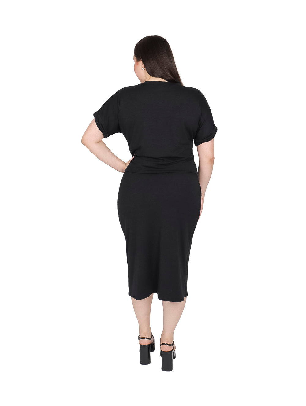 Mujer vistiendo un conjunto negro de camiseta y falda midi con abertura lateral.