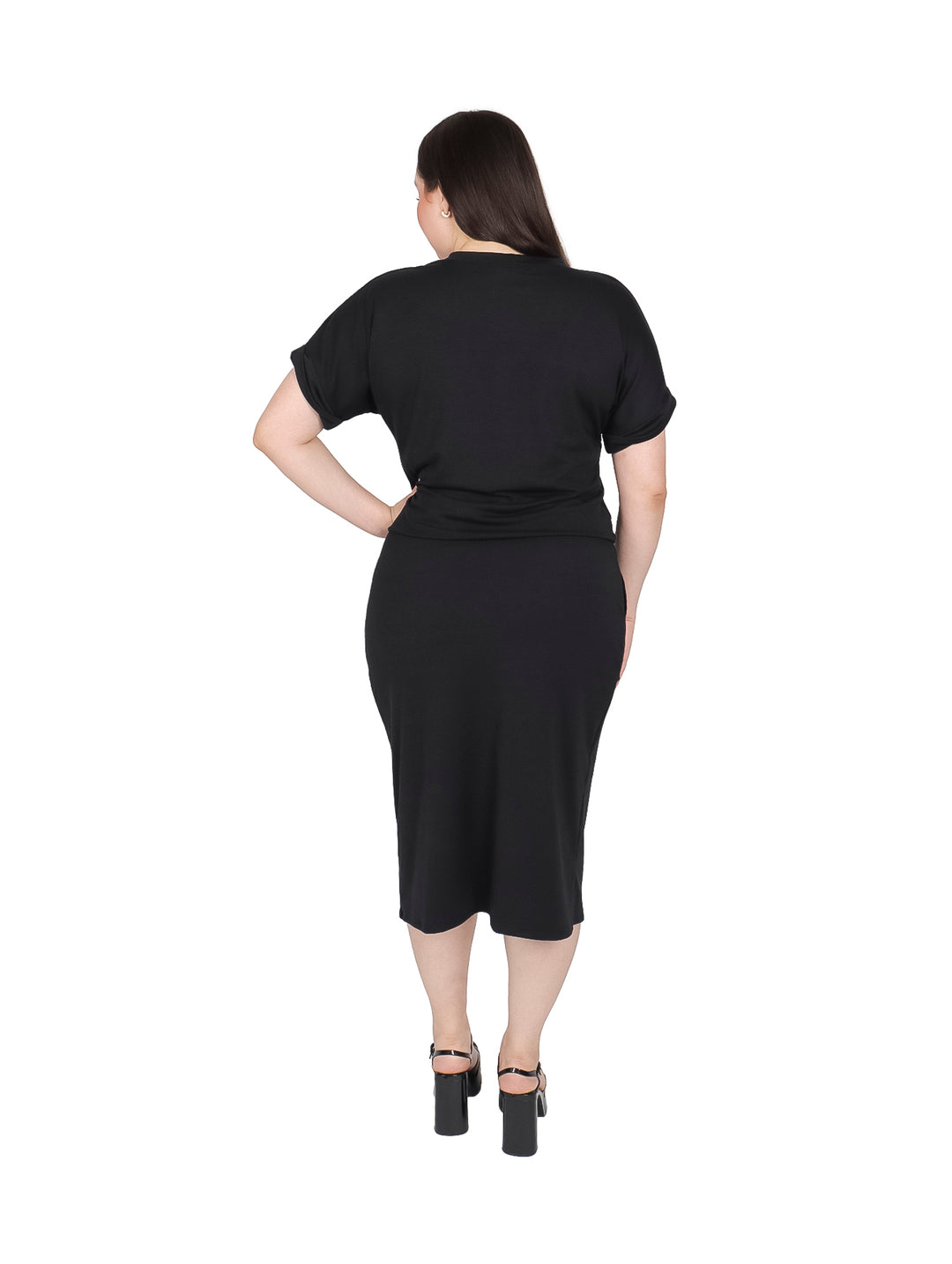 Mujer vistiendo un conjunto negro de camiseta y falda midi con abertura lateral.