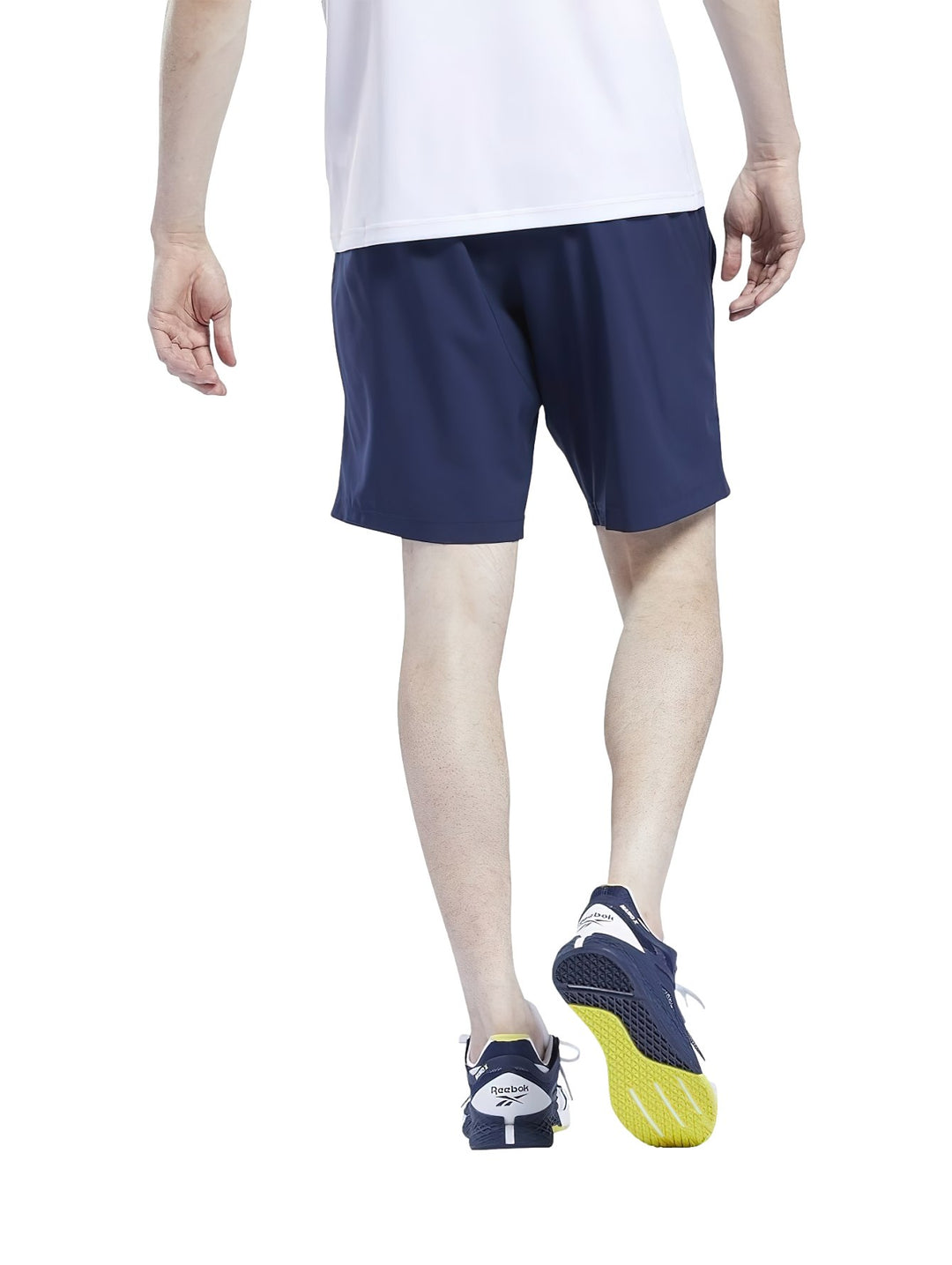 Hombre vistiendo shorts deportivos Reebok en color azul marino y camiseta blanca.