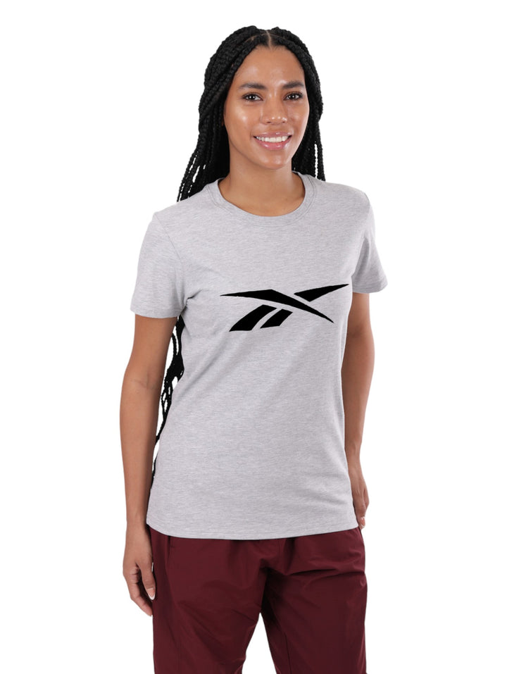 Mujer vistiendo una camiseta gris de algodón de manga corta con el logotipo de Reebok en el pecho.