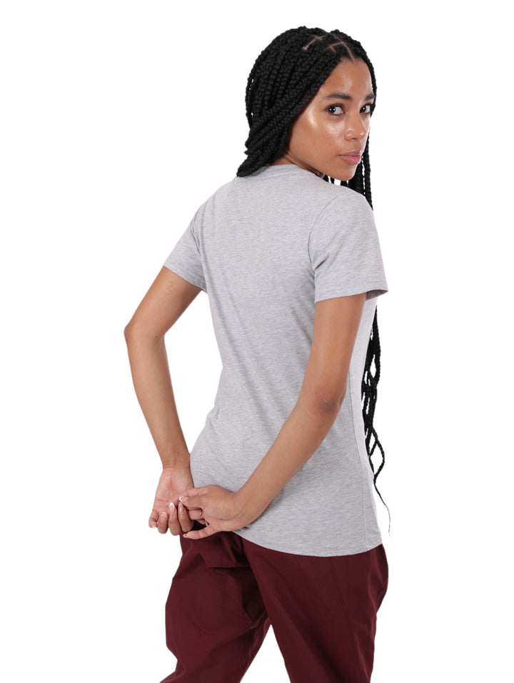 Mujer vistiendo una camiseta gris de algodón de manga corta con el logotipo de Reebok en el pecho.