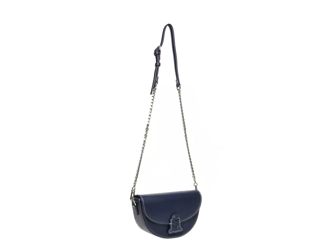 Bolso de hombro Steve Madden color azul marino con correa de cadena plateada y diseño semicircular.