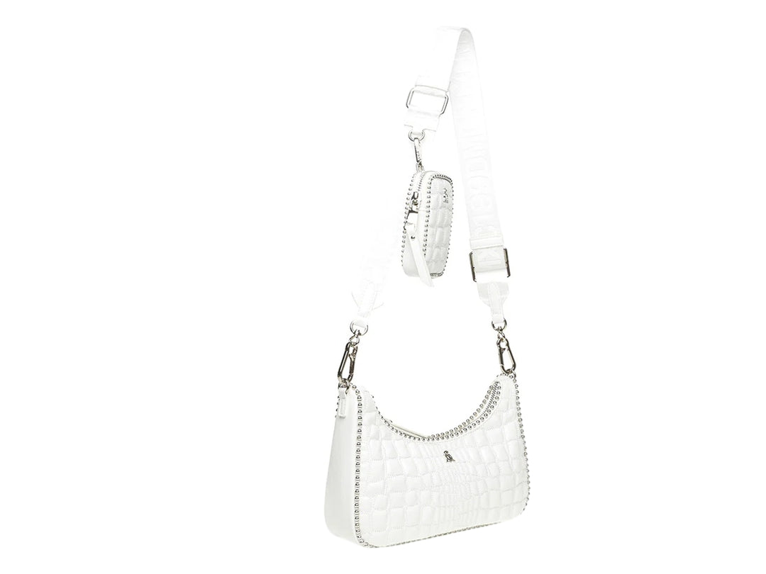 Bolso Steve Madden color blanco con textura acolchada, detalles plateados brillantes y una pequeña cartera acoplada.