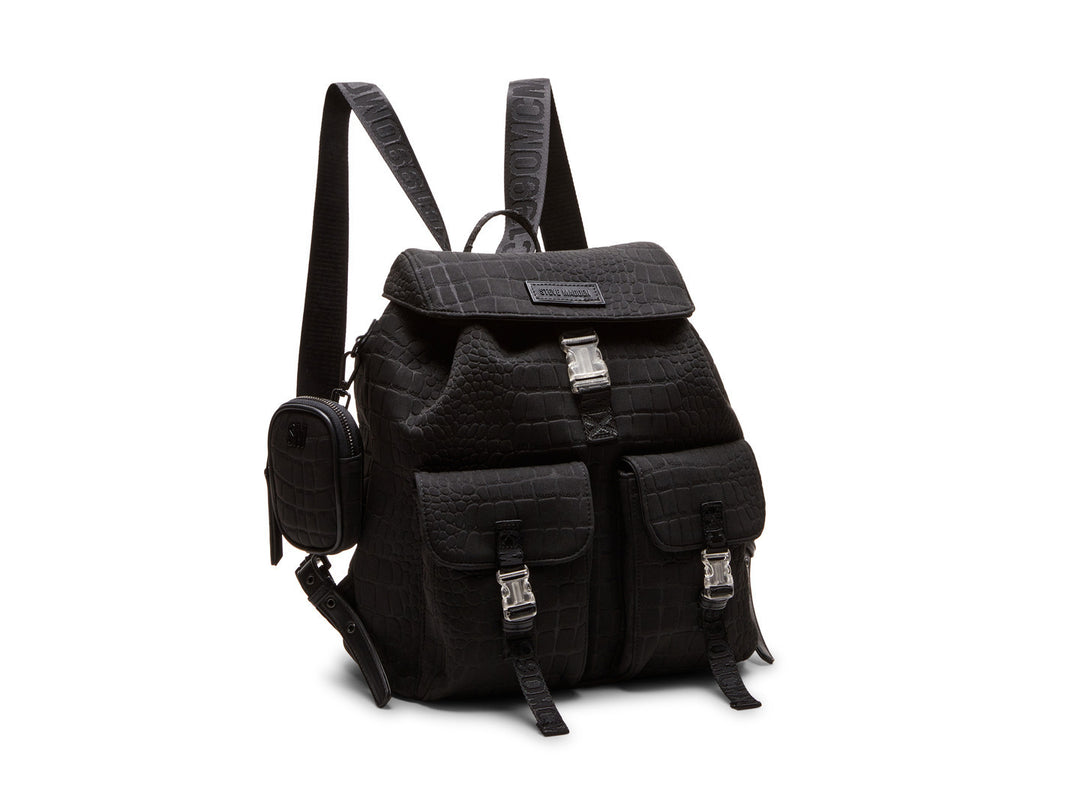 Mochila negra Steve Madden con textura rugosa, bolsillos frontales con hebillas plateadas y un pequeño bolso lateral.
