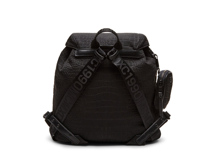 Mochila negra Steve Madden con textura rugosa, bolsillos frontales con hebillas plateadas y un pequeño bolso lateral.
