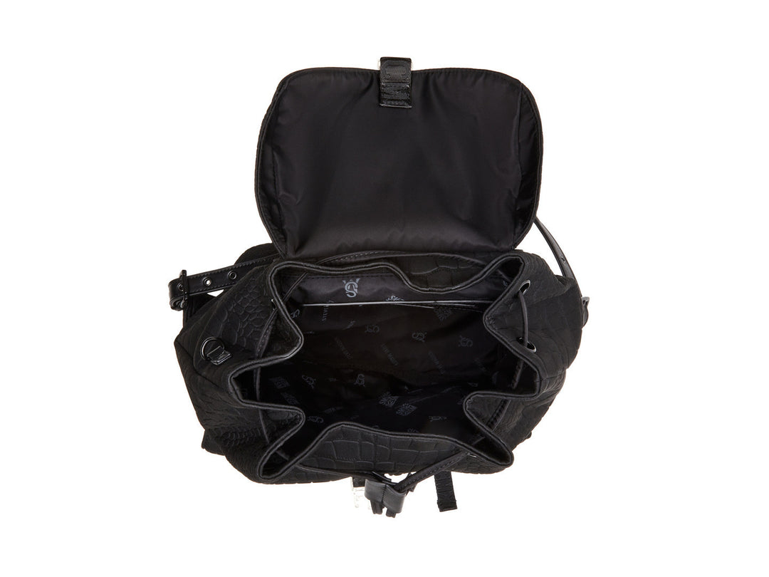 Mochila negra Steve Madden con textura rugosa, bolsillos frontales con hebillas plateadas y un pequeño bolso lateral.