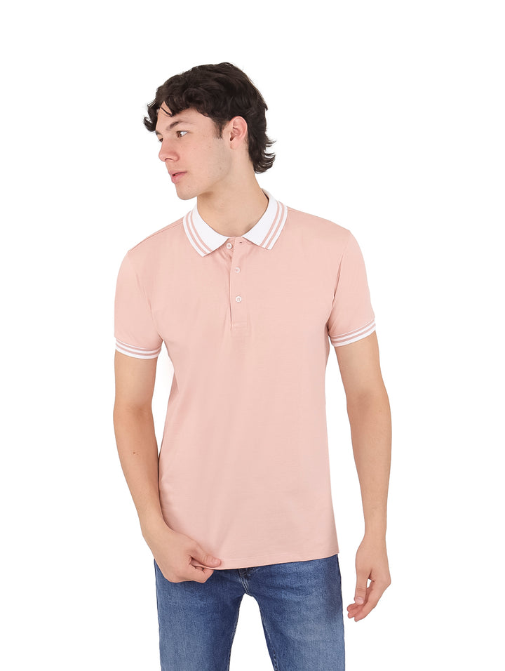 Hombre vistiendo playera polo color salmón con detalles blancos en el cuello y puños.