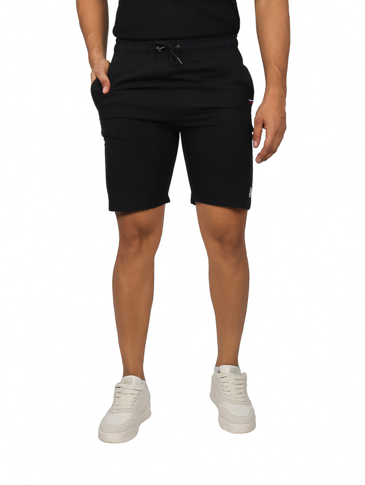 Hombre vistiendo shorts cortos de color negro con cordón ajustable en la cintura.