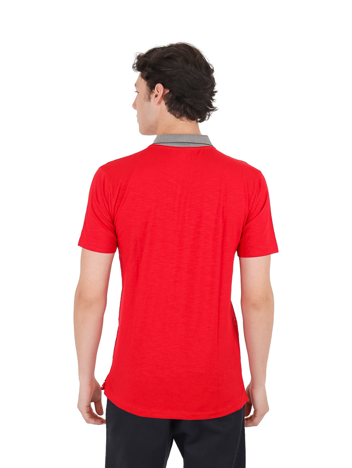 Hombre vistiendo playera polo roja con estampado de puntos blancos y cuello gris.